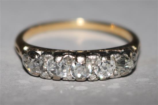 An 18ct gold and graduated five stone diamond half hoop ring, size M.